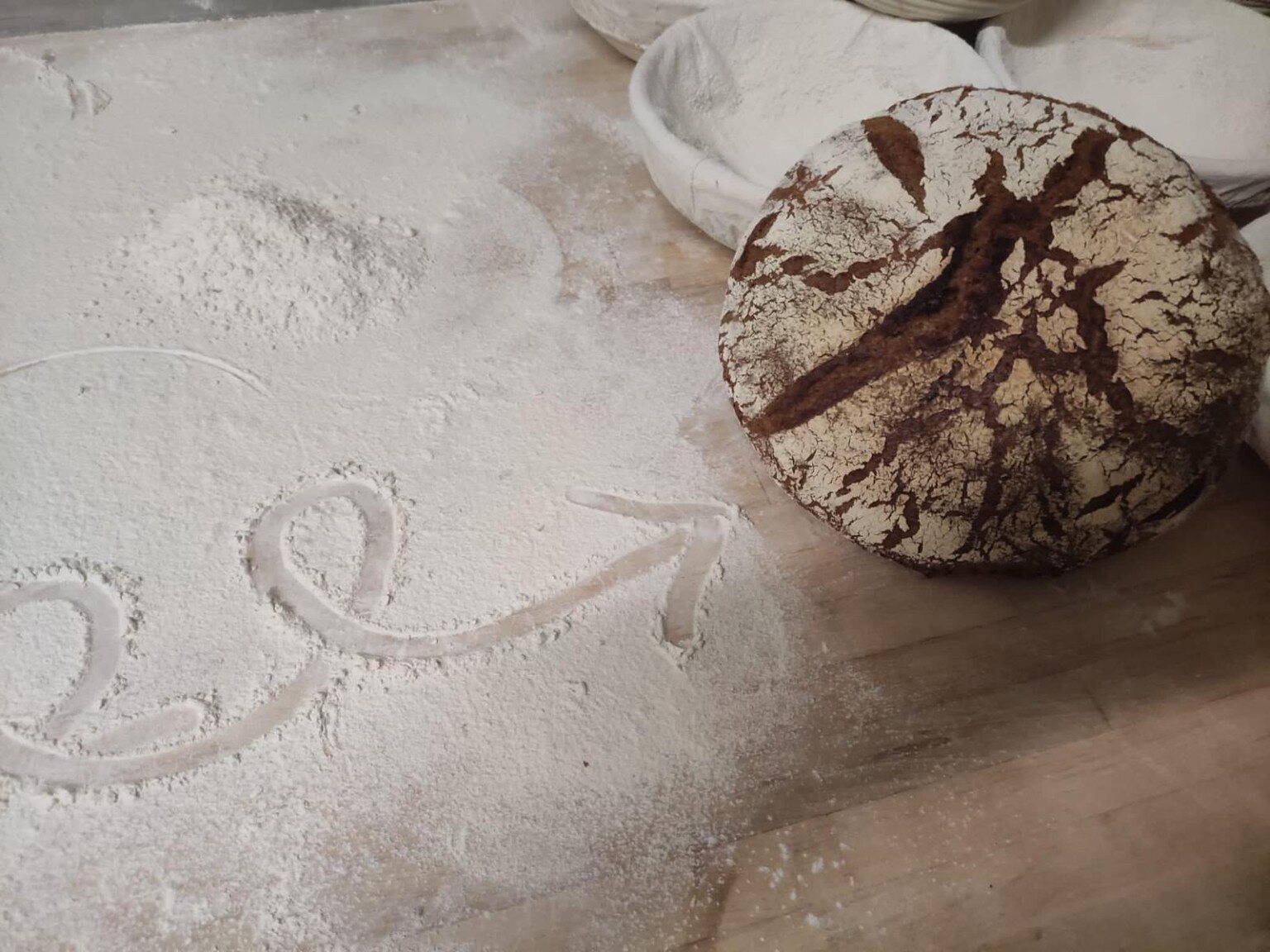 Frisch gebackenes Sauerteigbrot auf der bemehlten Arbeitsfläche
